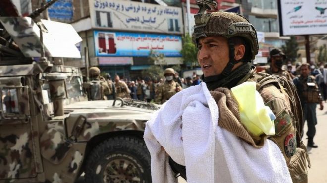 An Afghan soldier cradles a baby in his arms after the attack in Kabul