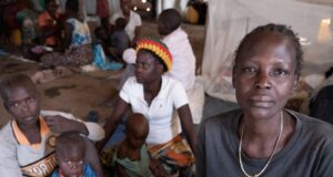 In the Democratic Republic of the Congo, Jeanette Buse Lasi, a widowed mother of four, sits with her children inside a communal shelter in an IDP camp in Bunia.