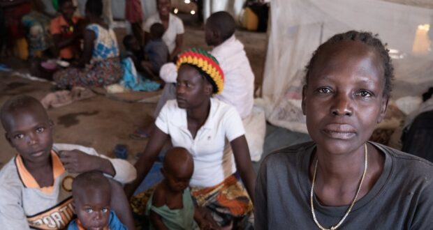 In the Democratic Republic of the Congo, Jeanette Buse Lasi, a widowed mother of four, sits with her children inside a communal shelter in an IDP camp in Bunia.